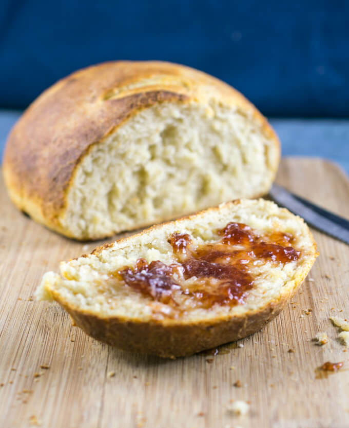 A slice of vegan potato bread spread with strawberry jam