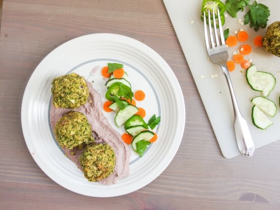 Three crispy healthy gluten free and vegan baked kale falafel subtly spiced with cumin, paprika, and coriander served in cava mezze kalamata olive hummus with veggies to drip and cilantro 