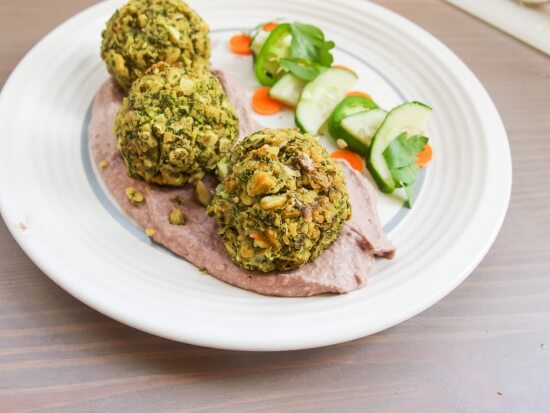 Close up of three vegetable and nutrition packed baked not fried kale falafel served with hummus and jalapeno - a healthy maryland take on a mediterranean classic