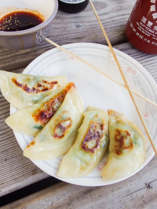 Vegan Avocado Edamame Potstickers served with a sweet and spicy tamari and sriracha dipping sauce and garnished with sesame seeds and scallions - Yup, it's Vegan