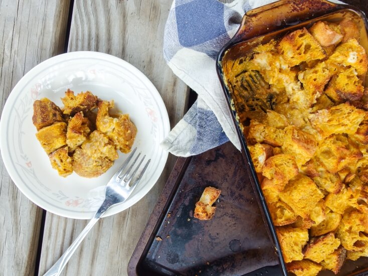 White plate with a big serving of beautifully browned pumpkin bread pudding - perfect for October, Halloween, or Fall nights with a scoop of vanilla ice cream