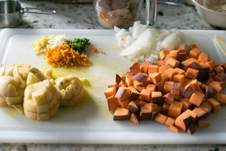 Mise en place for chickpea turmeric stew: minced garlic, ginger, turmeric, and jalapeno; diced potato; and diced onion