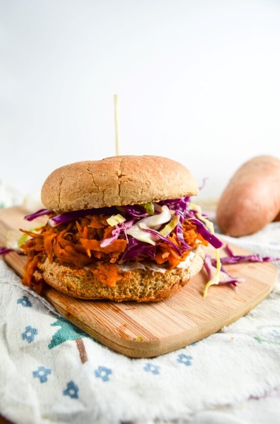 Spicy and savory, gluten free option of a comforting summer favorite. Messy hot sauce and garlic bbq sweet potato topped with crunchy purple and green cabbage slaw and a sprouted sandwich roll with a smear of cultured cashew cream cheese | yupitsvegan.com