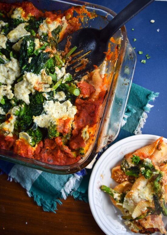 A hearty vegan pasta bake with creamy cauliflower and tofu ricotta, spiced with nutritional yeast, red pepper flakes, oregano, and lemon juice served in stuffed shells with healthy nutrient dense rapini | yupitsvegan.com