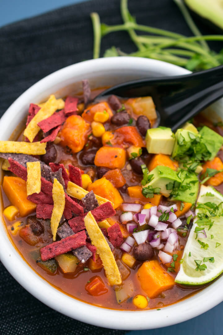 Photo showing sweet potato cubes and black beans being spooned out of a bowl.