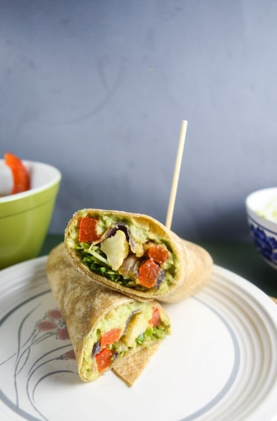 Closeup of a Roasted Vegetable Avocado Garden Wrap - warming and satisfying slow roasted vegetables on a lemon pepper avocado mash with a freshly warmed roll