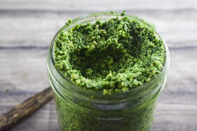 Close up of a homemade vegan pesto - packed with greens and umami flavor, spiced with nutritional yeast and lemon, with an oil-free option