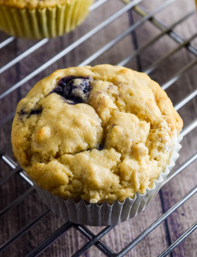 Closeup of crispy and fluffy vegan lemon blueberry aquafaba muffin on a cooling rack