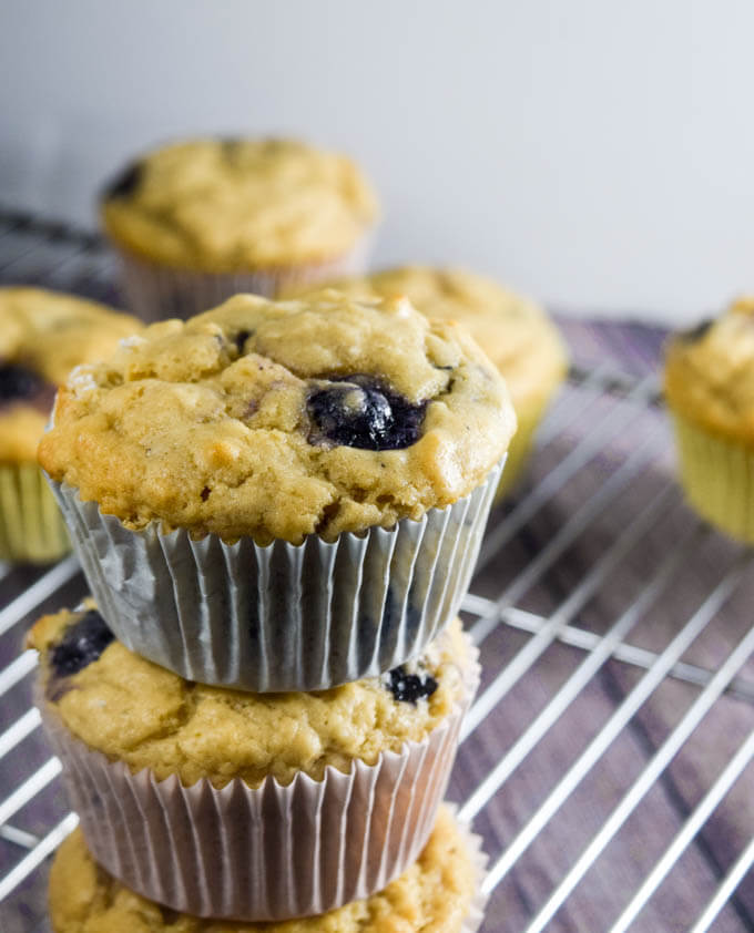 A stack of three sweet and delicious fluffy vegan Lemon Blueberry Muffins - and a review/giveaway of Aquafaba by Zsu Dever | https://yupitsvegan.com/