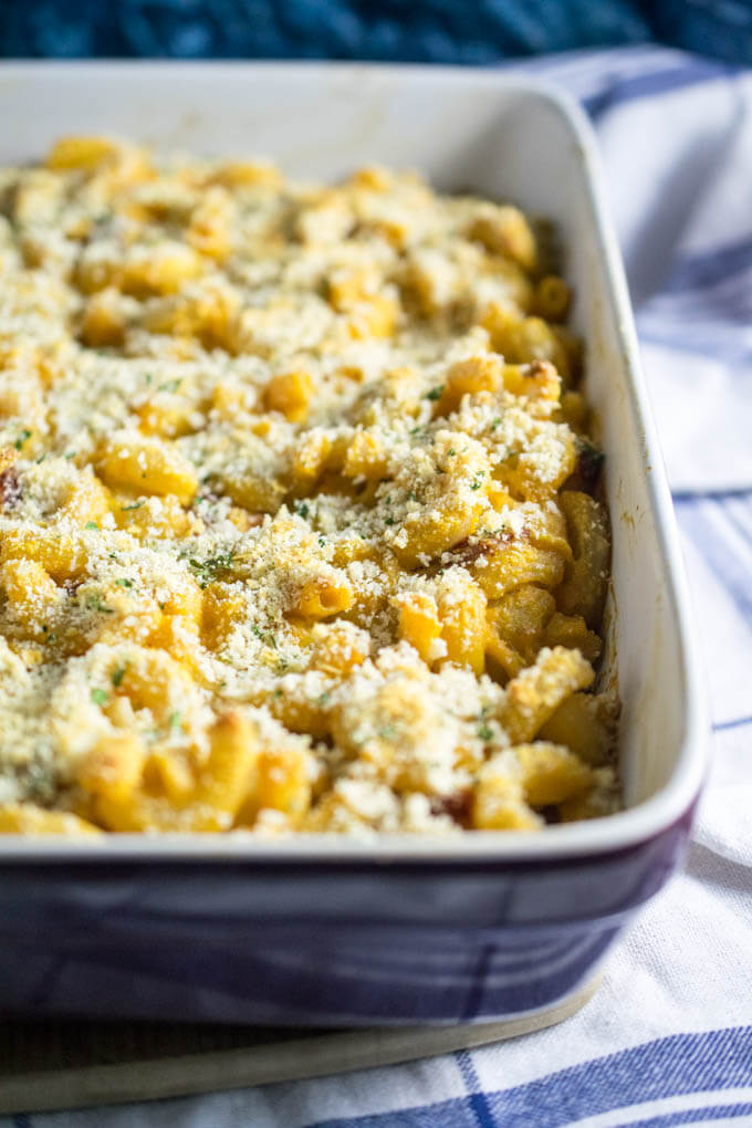 Close up of one blue pan of rich dairy free mac and cheese topped with panko and nutritional yeast breadcrumbs