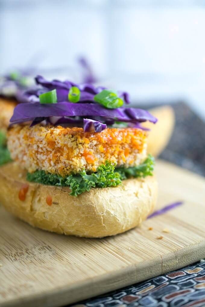 Close up of vegan buffalo tofu sliders - chewy tofu coated in crisp bread crumbs with fresh vegetables and a scallion garnish