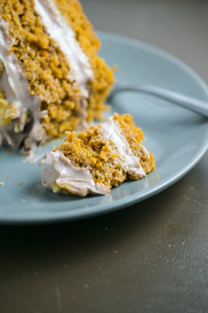 Close up of one bite of cinnamon-spiced sweet potato cake and a large dallop of creamy toasted walnut frosting made with coconut oil, cashews, walnuts, and vegan yogurt for a healthy treat