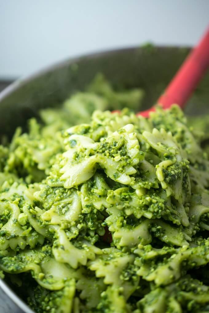 Close-up of tender al dente bowtie pasta with chunky spinach edamame basil pesto coating it