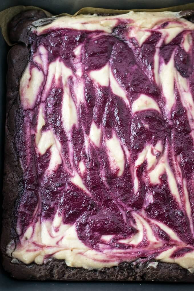 Vanilla-infused fresh cherries swirled with cashew cream makes the perfect vegan berry cheesecake topping for these eggless brownies.