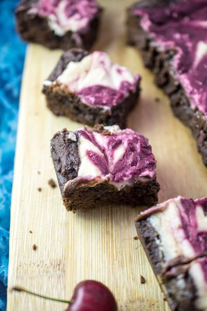 Close-up of dairy-free, egg-free brownies that are moist and fudgy on the inside with a slightly crispy crust and topped with a creamy cherry cheesecake swirl.