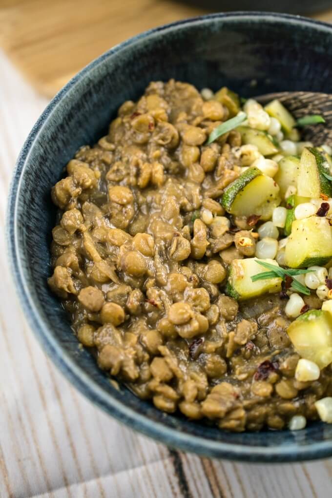 Creamy and delicious miso lentil stew close-up served in a bowl with zucchini and tarragon.