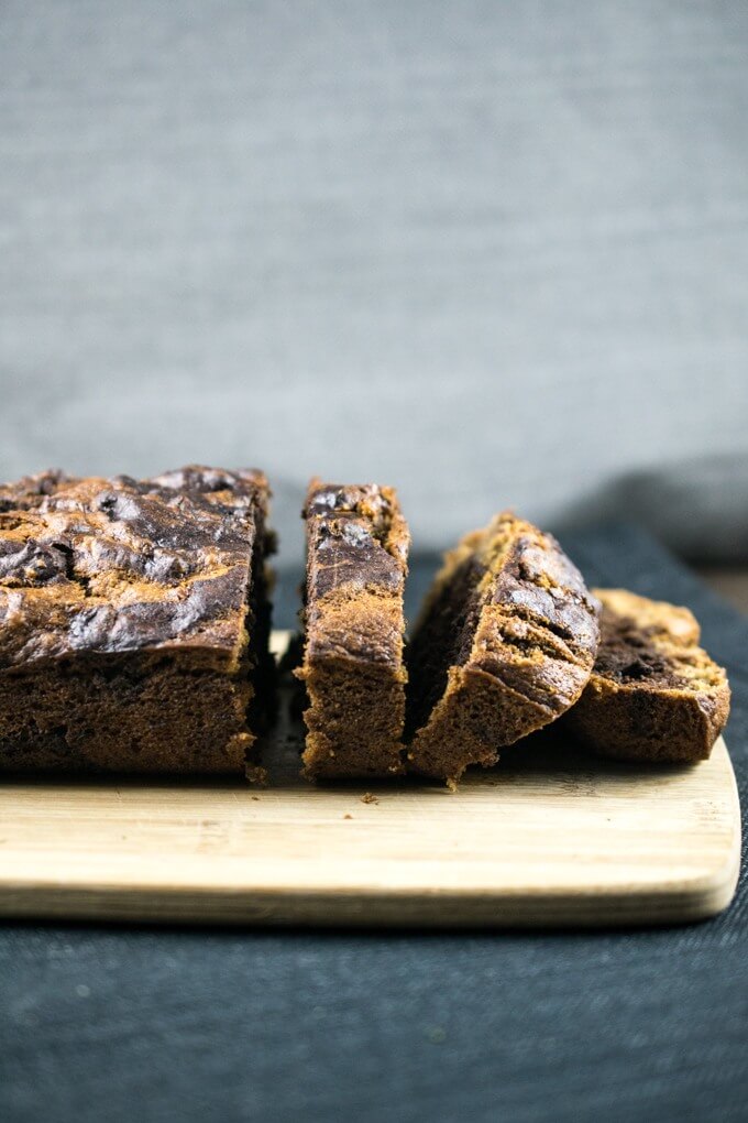 Slices of marbled vegan chocolate banana bread stacked on a cutting board with a grey background