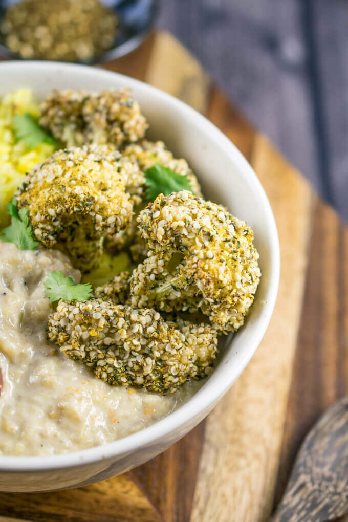 Close-up of a za'atar crusted cauliflower floret. It is clear the batter has adhered perfectly to the cauliflower, with an array of hemp seeds visible.