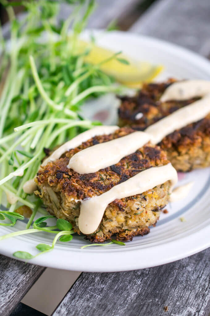 A plate arranged with two vegan crab cakes, drizzled with vegetarian Thousand Island dressing