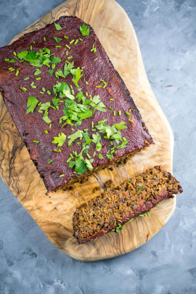 Overhead view of vegan lentil meatloaf with tomato and apple cider glaze, and one slice cut