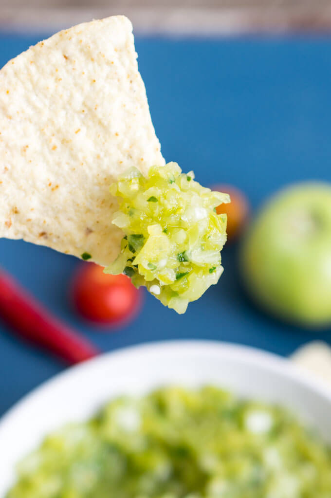 Close-up of green tomato salsa on a tortilla chip