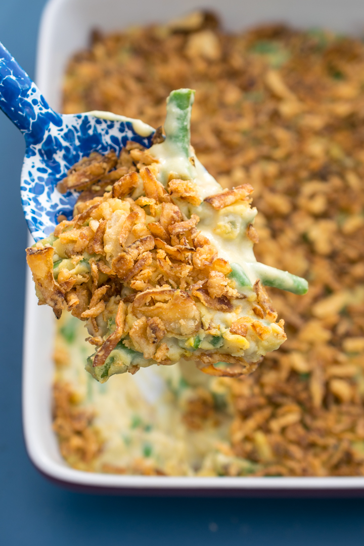 A scoop of vegan green bean casserole being ladled out of the baking dish