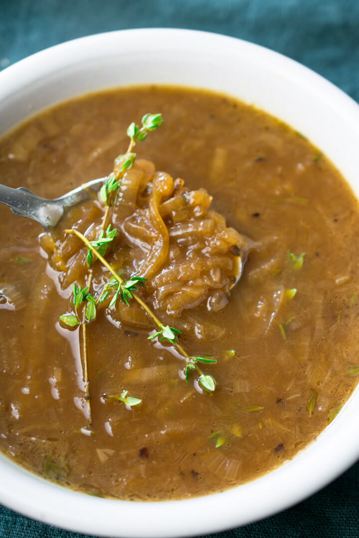 Close-up of vegan French onion soup showing the inviting deep brown color and tender texture of the onions