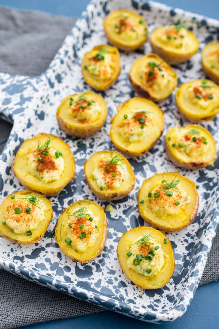 A tray of deviled potatoes, which are oblong and garnished to resemble deviled eggs